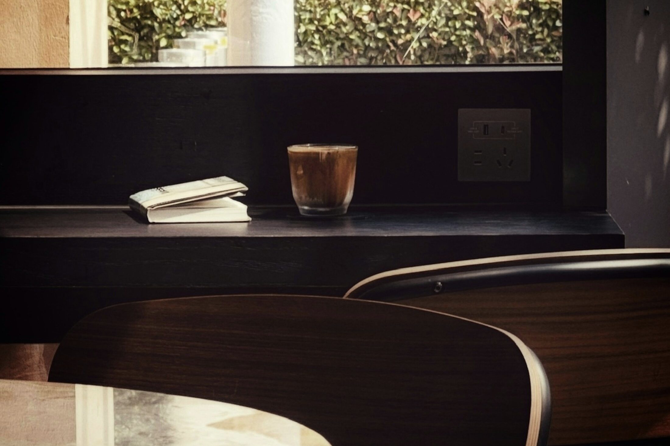 A book and a glass left on a window ledge. Illustrative stock photograph, not an Almajour property